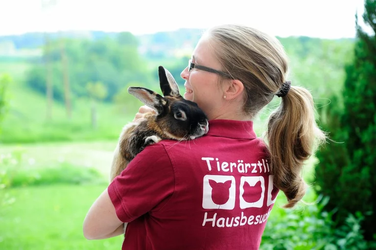 Mobile Tierärztin mit Kaninchen auf dem Arm beim Hausbesuch in Coburg